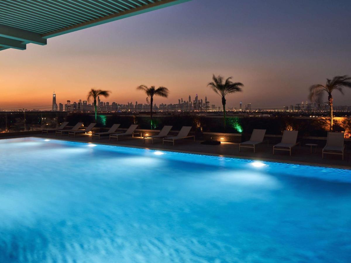 Movenpick Jumeirah Village Triangle Dubai Exteriör bild The swimming pool at the hotel