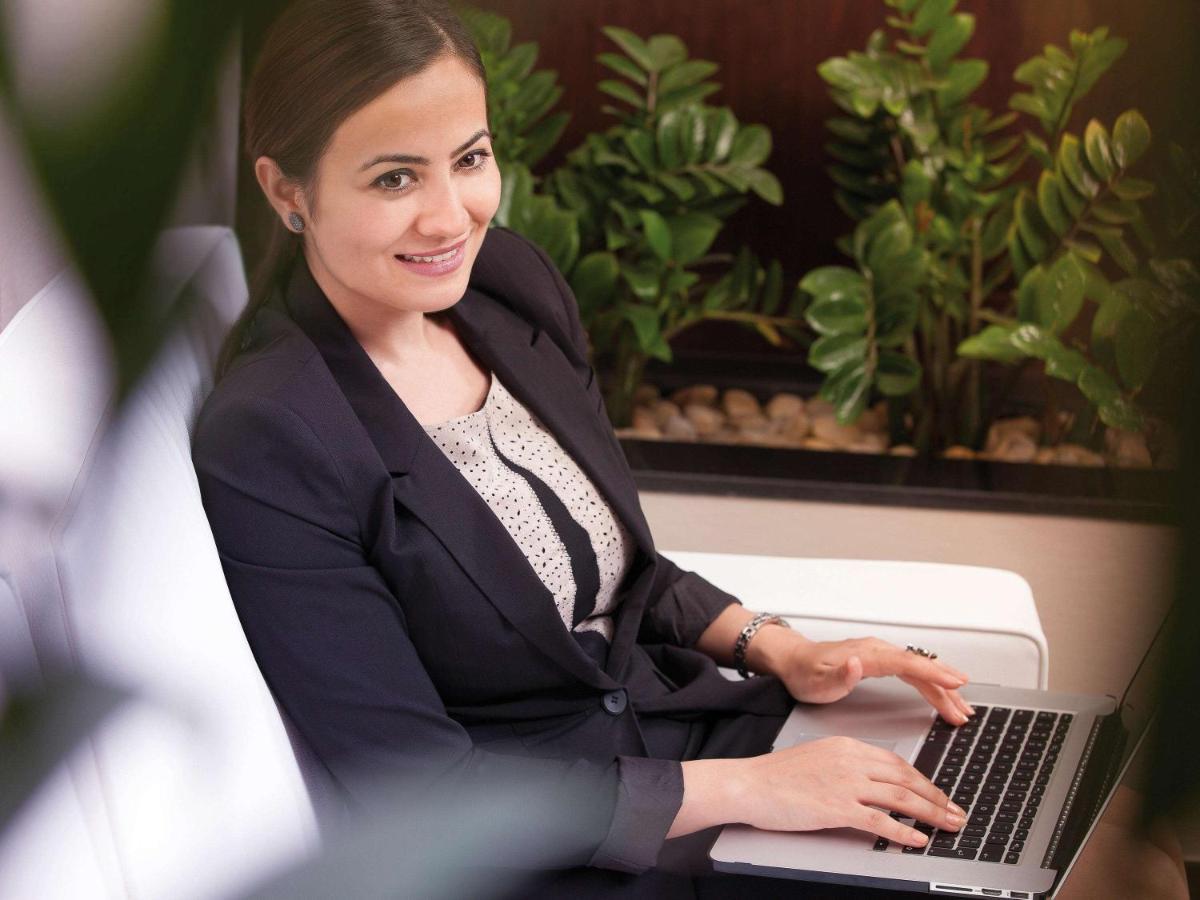 Movenpick Jumeirah Village Triangle Dubai Exteriör bild A business woman working on a laptop